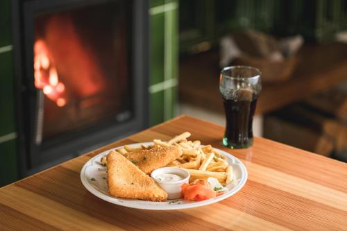 a plate of french fries and a sandwich and a glass of soda at Chatky Skalní mlýn Adršpach in Adršpach