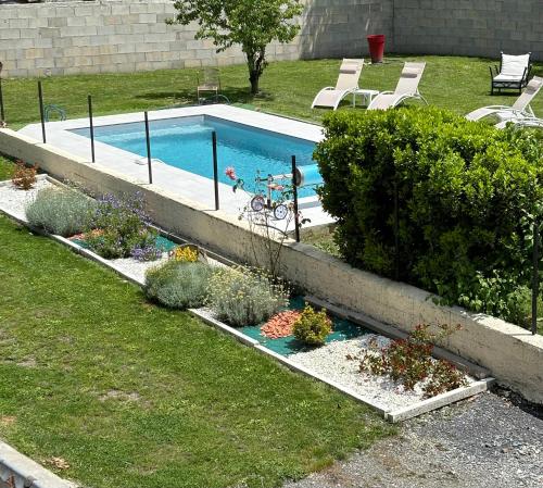 a swimming pool with plants in a yard at La Maison d'hôtes LA PUYERRE in Hours