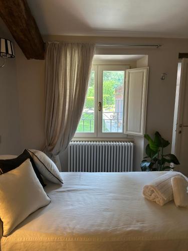 a bedroom with a large bed with a window at Burlamacchi Villas in Bagni di Lucca
