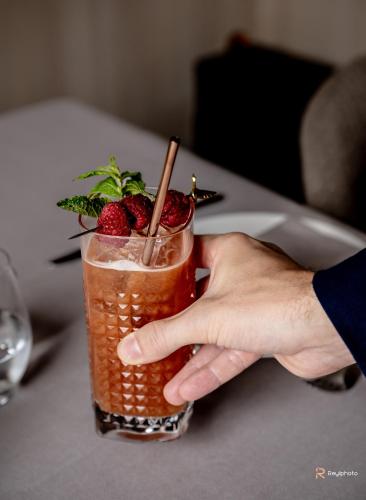 a person holding a drink with a strawberry on it at Badia Hill in Badia