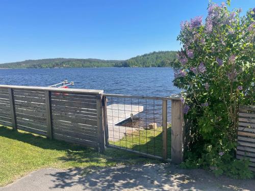 a fence with a gate on the side of a lake at New house by the lake Bunn & private bathing jetty in Gränna