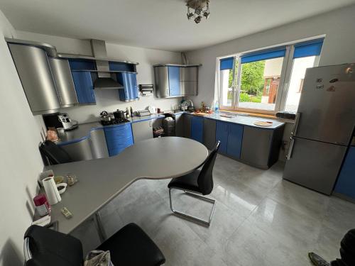 a kitchen with blue cabinets and a table with chairs at Noclegi Gródek nad Dunajcem in Gródek Nad Dunajcem