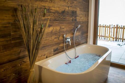 a bath tub with a shower in a room at Nationalpark Chalet Schneespitze in Neukirchen am Großvenediger