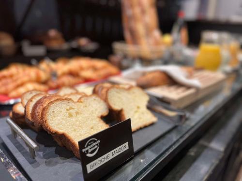 a bakery display case with bread and other pastries at Brit Hotel Du Dauphin L'Aigle in LʼAigle