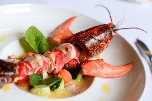 a plate of food with a lobster on it at Brit Hotel Du Dauphin L'Aigle in LʼAigle