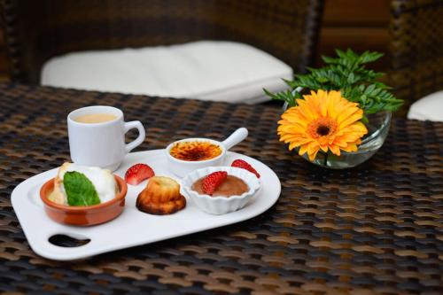 a plate of food and a cup of coffee on a table at Brit Hotel Du Dauphin L'Aigle in LʼAigle
