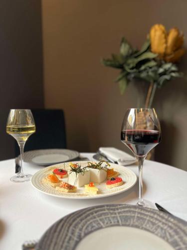 a plate of food on a table with two wine glasses at Brit Hotel Du Dauphin L'Aigle in LʼAigle