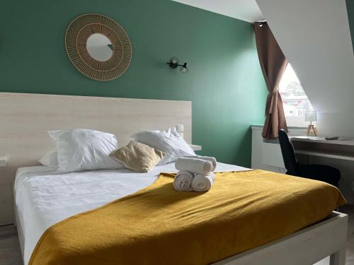 a teddy bear sitting on top of a bed at Brit Hotel Du Dauphin L'Aigle in LʼAigle