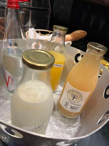 two bottles of milk and two bottles of orange juice at Brit Hotel Du Dauphin L'Aigle in LʼAigle