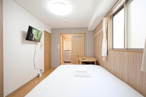 a bedroom with a white bed and a window at Mi-APT MIDORI in Tokyo