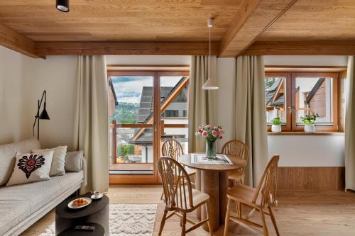 a living room with a couch and a table and chairs at IJG Imperial Apartamenty Smrekowa in Zakopane