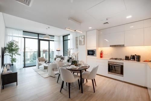 a kitchen and living room with a table and chairs at Palace Residence, Dubai Creek Harbour - Mint Stay in Dubai