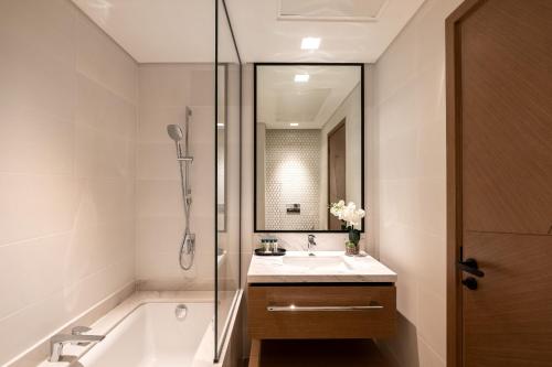 a bathroom with a tub and a sink and a shower at Palace Residence, Dubai Creek Harbour - Mint Stay in Dubai