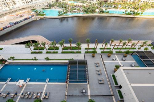 an aerial view of a hotel pool with palm trees at Palace Residence, Dubai Creek Harbour - Mint Stay in Dubai