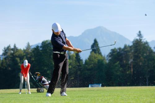 a man swinging a golf club on a field at Elegans Hotel Brdo in Kranj