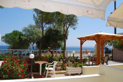 a patio with a table and chairs and flowers at Angela Studios in Karfas