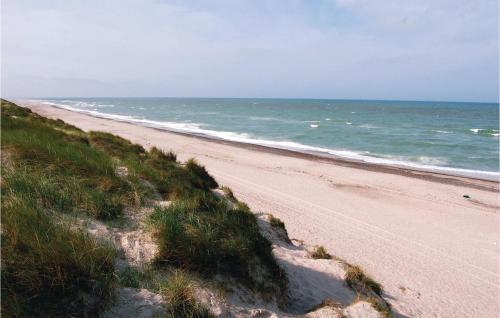 an empty beach with the ocean in the background at Holiday Home Arvidvej I Dnmk in Bjerregård