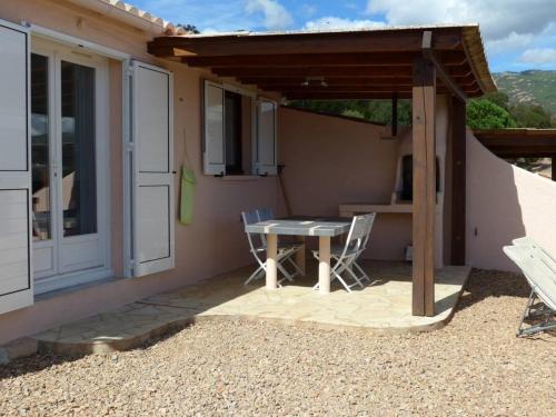 a patio with a table and chairs in front of a house at Domaine San Sebastiano in Porto-Vecchio
