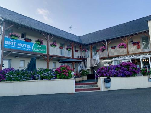 a hotel with flowers and plants in front of it at BRIT HOTEL Lannion-Perros Guirec in Lannion