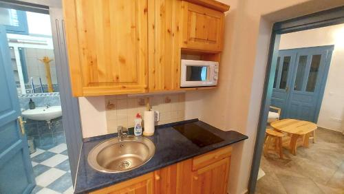 a bathroom with a sink and a microwave at Kék Mátra Vendégház in Matraszentistvan
