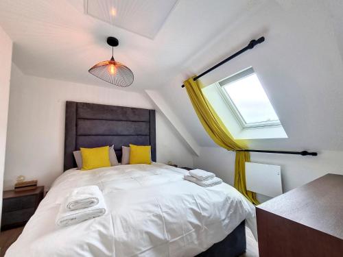 une chambre avec un lit avec des oreillers jaunes et une fenêtre dans l'établissement Mont Gîte Des Herbus Salicorne 6personnes entre Granville et Mont Saint Michel, à Vains