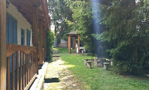 a path between two buildings with a fence and a tree at Kék Mátra Vendégház in Matraszentistvan