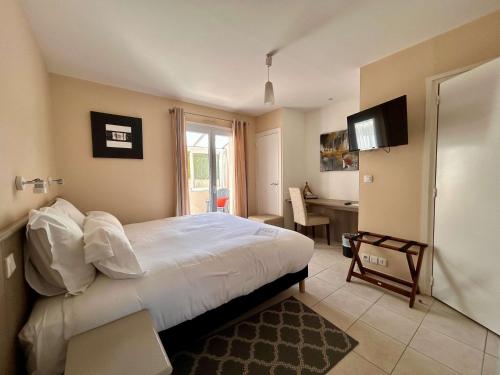 a bedroom with a bed and a desk in it at BRIT HOTEL Lannion-Perros Guirec in Lannion