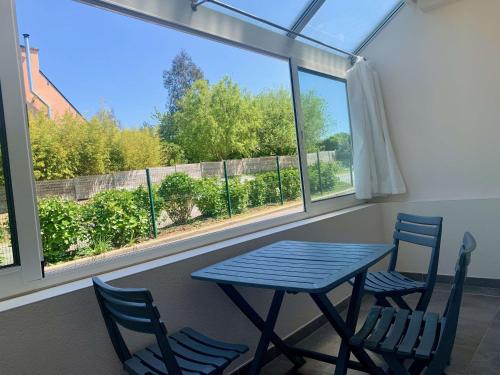 a table and chairs in a room with a window at BRIT HOTEL Lannion-Perros Guirec in Lannion
