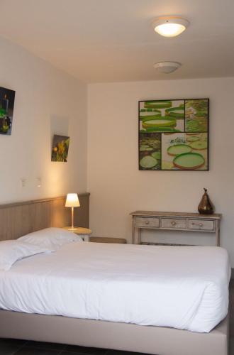 a bedroom with a white bed in a room at BRIT HOTEL Lannion-Perros Guirec in Lannion