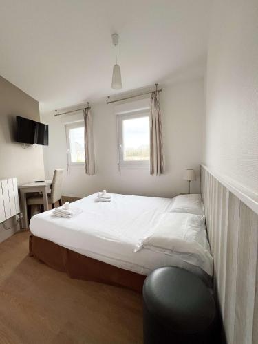 a bedroom with a large white bed with a window at BRIT HOTEL Lannion-Perros Guirec in Lannion