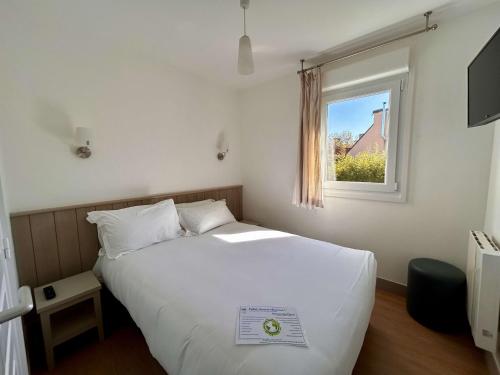 a bedroom with a white bed and a window at BRIT HOTEL Lannion-Perros Guirec in Lannion