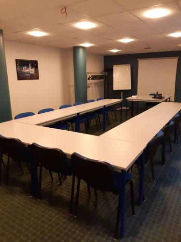 a classroom with tables and chairs and a whiteboard at Brit Hotel Mulhouse Centre in Mulhouse