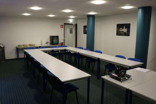 a room with tables and chairs and blue chairs at Brit Hotel Mulhouse Centre in Mulhouse