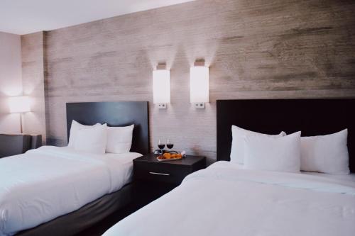 two beds in a hotel room with white pillows at Normandy Farm Hotel & Conference Center in Blue Bell