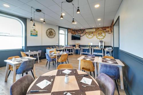 uma sala de jantar com mesas e cadeiras e uma cafeteria em Brit Hotel Roanne - Le Grand Hôtel em Roanne
