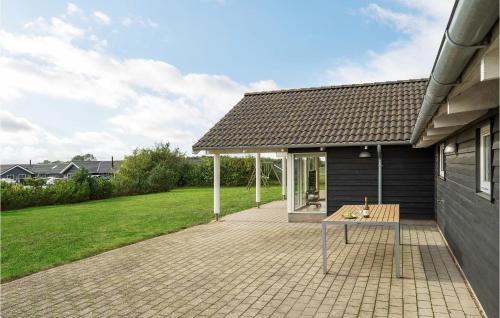 a patio with a table in front of a house at Holiday Home Fiskekrogen Stege Xi in Stege