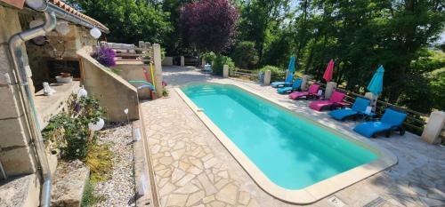 une piscine vide avec des chaises et des parasols dans l'établissement Petite Maison Papillon, Pool, hot Tub,Relax, à Saint-Vincent-Jalmoutiers
