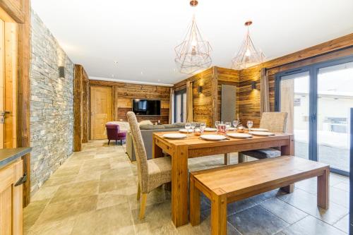une salle à manger avec une table et des chaises en bois dans l'établissement Homency - Chalet La Biche, à L'Alpe-d'Huez