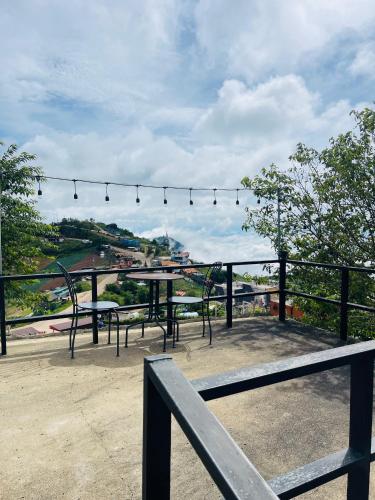 a group of tables and chairs sitting on top of a roof at Rai Saeng Tawan at Phu Thap Buek in Ban Maeo Thap Boek