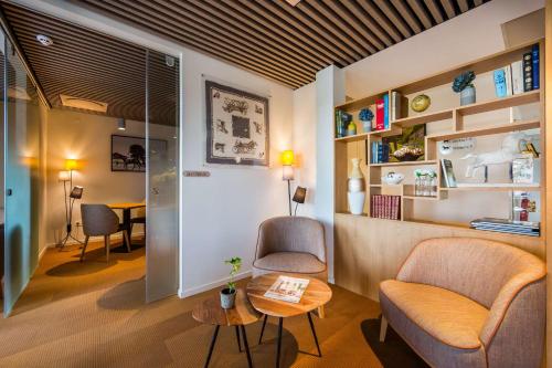 a living room with a couch and a table at Brit Hotel Ploermel - Hotel de l'Hippodrome in Ploërmel