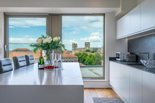 a kitchen with a table with flowers and a window at Minster View Penthouse at Ryedale House in York
