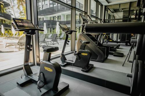 a gym with treadmills and elliptical machines at Bursztynowe Resort&SPA Stegna in Stegna