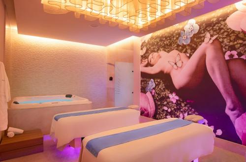 a room with two beds and a painting on the wall at Desire Riviera Maya Resort All Inclusive - Couples Only in Puerto Morelos