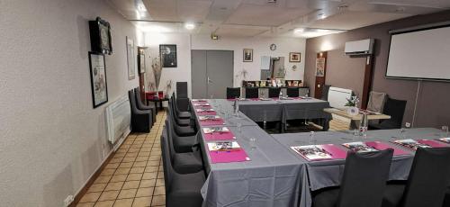 a conference room with long tables and black chairs at Brit Hotel Besancon l'Horloge in Besançon