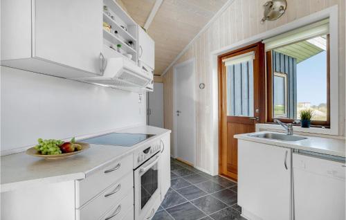 a kitchen with white cabinets and a sink and a window at Holiday Home Baldersvej Askeby Ix in Askeby