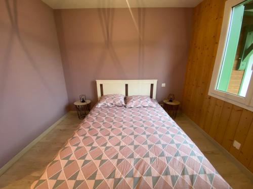 a bed in a room with two end tables at Villa landaise à 9km de l'Océan in Saint-Julien-en-Born