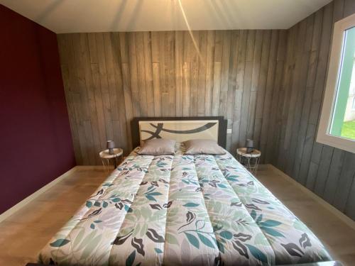 a bedroom with a bed with a wooden wall at Villa landaise à 9km de l'Océan in Saint-Julien-en-Born