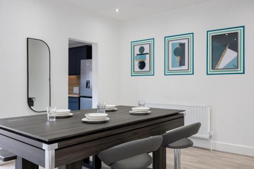 a dining room with a wooden table and two chairs at Modern Cozy Home, Cinema & Games Room, Sleeps 8 in Bolton