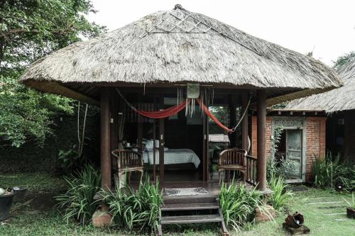 a small hut with two chairs and a bed at Ketewel Bed & Breakfast Niti Room in Ketewel