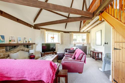 een woonkamer met een bank en een tv bij Grade II Old Engine House, on the SW Coast Path in Noss Mayo